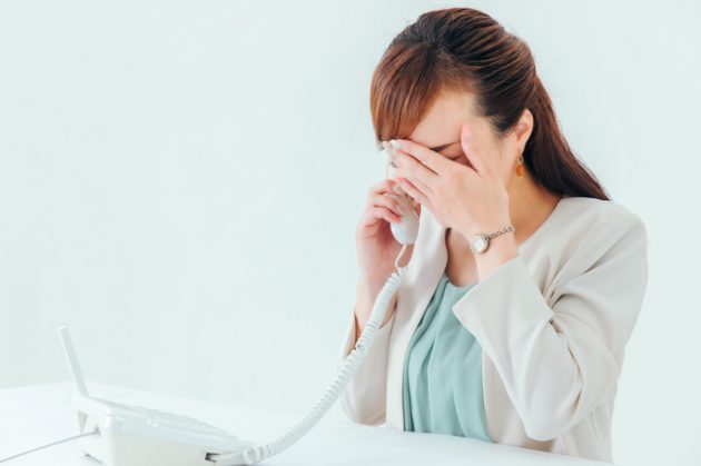 喪中に年賀状を出したことを電話でお詫びする女性